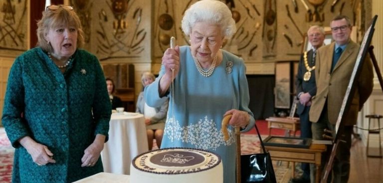 En la imagen, la Reina Isabel partiendo su pastel por sus 70 años en el trono