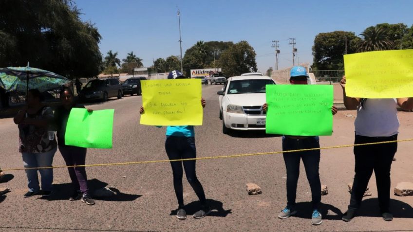 Padres cierran calle para exigir clases presenciales en Cajeme; escuela está vandalizada