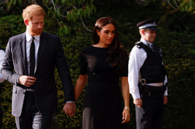 Meghan Markle y el Príncipe Harry miran los ramos de flores