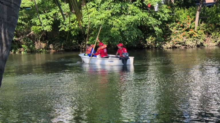 Personal de rescate a bordo de la lancha, en búsqueda de los restos humanos