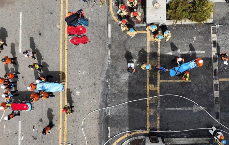 Bomberos transportan cadáveres tras el incendio