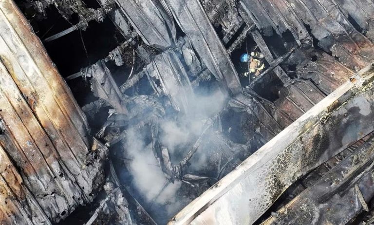 Un rescatista busca personas atrapadas entre los escombros