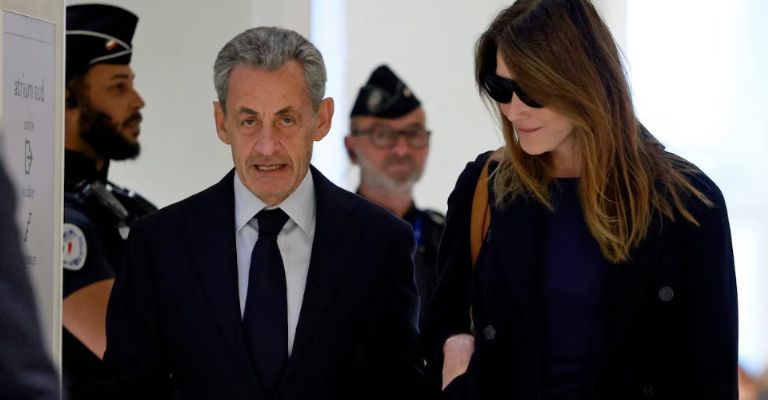 escoltado por su esposa, la cantante Carla Bruni-Sarkozy