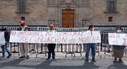 Militantes de Morena protestan frente a Palacio Nacional; escriben con sangre sus pancartas