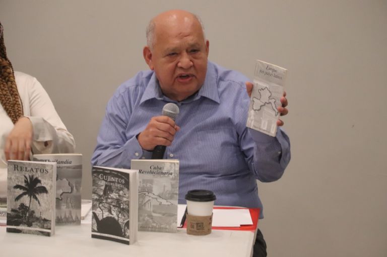 Miguel Ángel Castro Cosío mostrando uno de sus libros