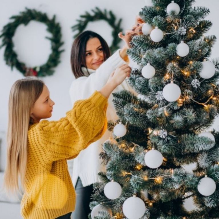 Familia adornando su árbol de Navidad con esferas