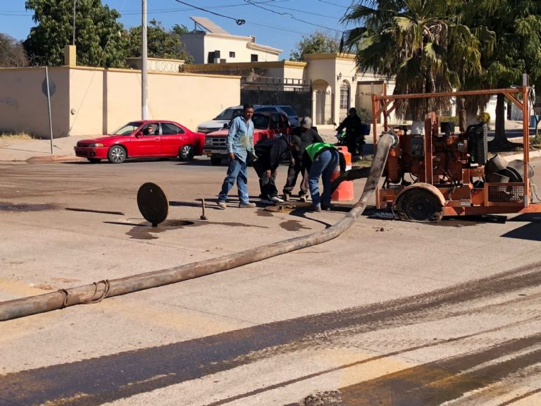 Adultos mayores cruzando aguas negras