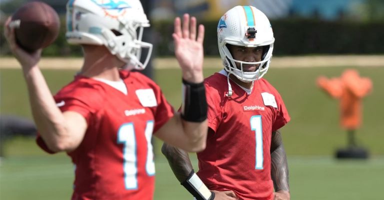 Tua observa el QB suplente, Tim Boyle durante la práctica