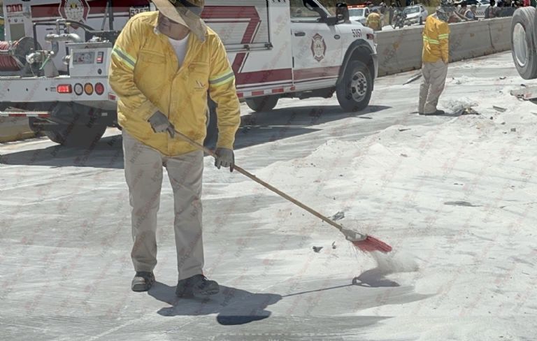 Personal limpia el azúcar esparcido sobre la autopista