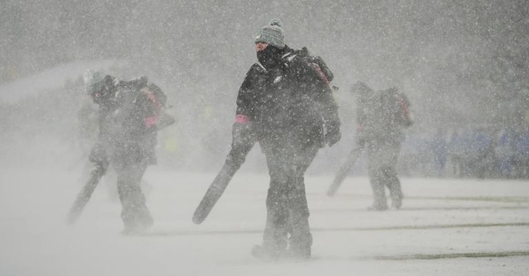 Trabajadores del estadio limpian el terreno de juego