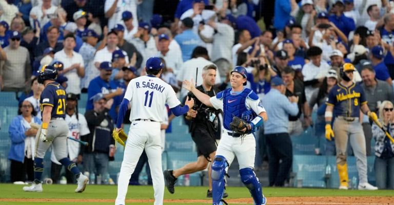 Sasaki celebra con su receptor Will Smith el último out