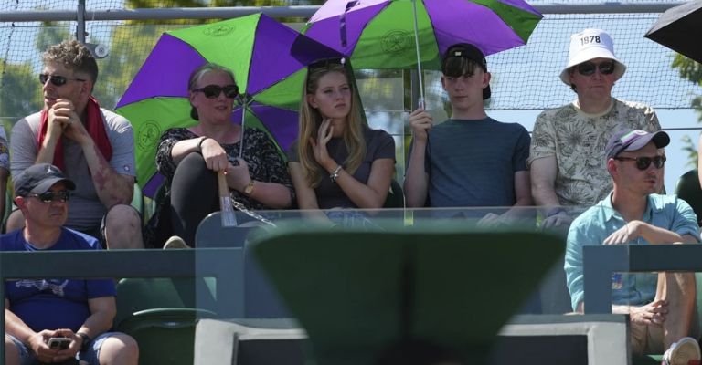 Aficionados buscan protegerse del fuerte sol