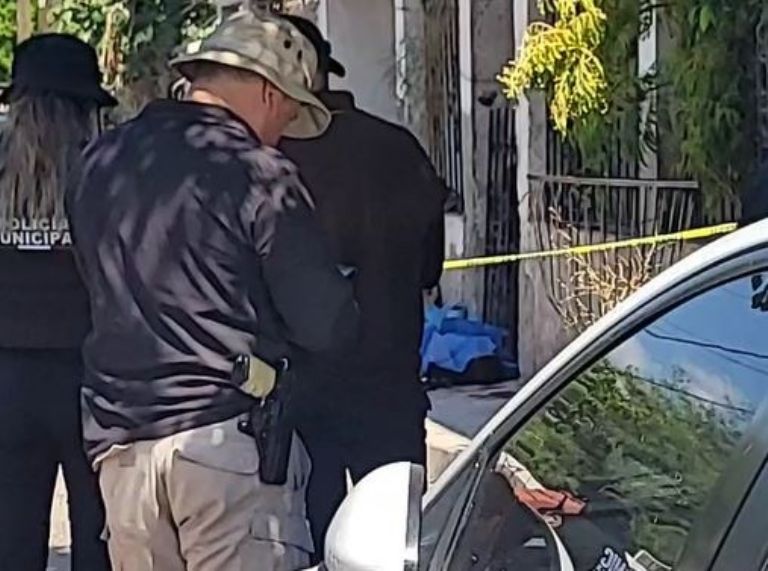 El cuerpo fue cubierto con una sábana azul sobre la banqueta