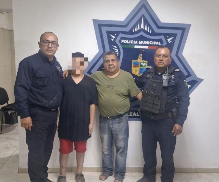 El menor junto a los policías que le ayudaron a salir del canal